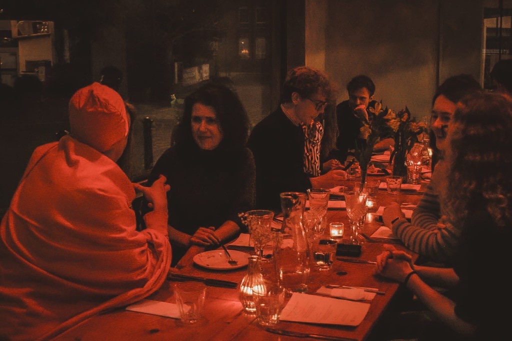 Red-lit dinner table gathering